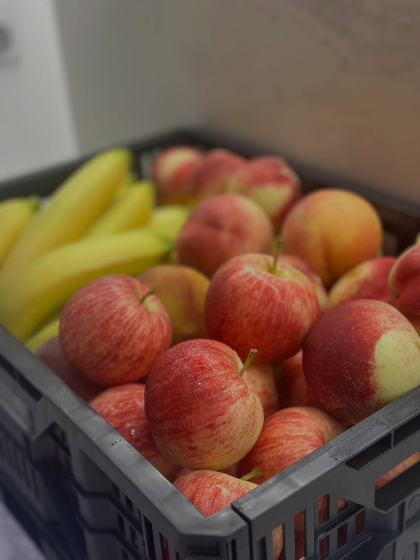 Crate of gala apples and bananas at a workplace